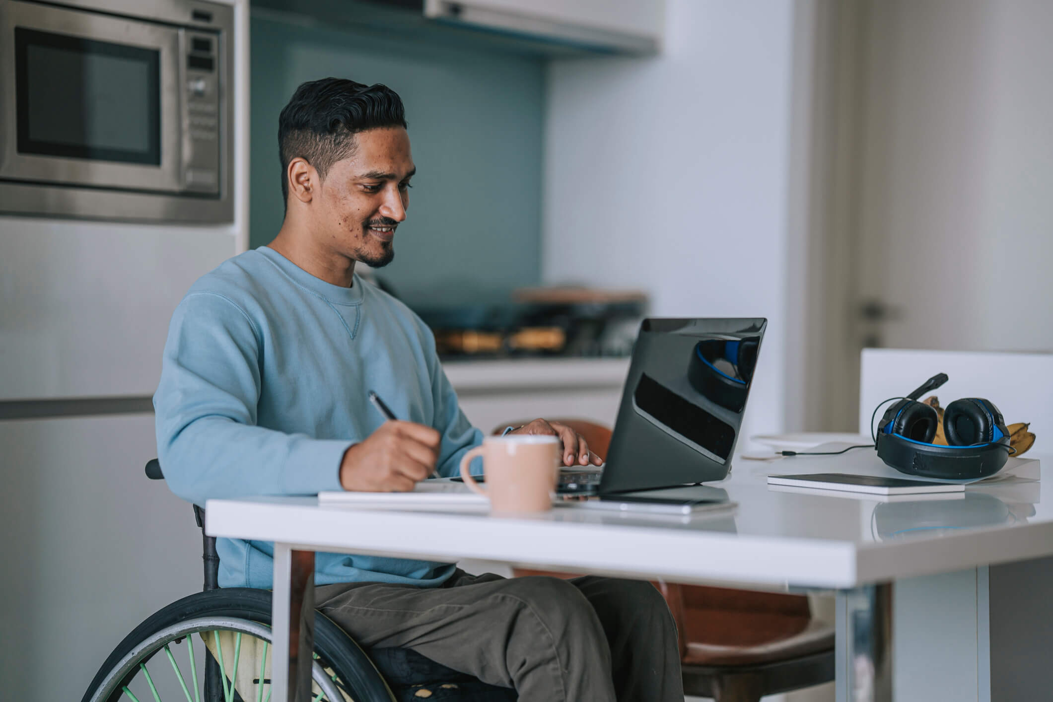 man-in-wheelchair-taking-notes-laptop
